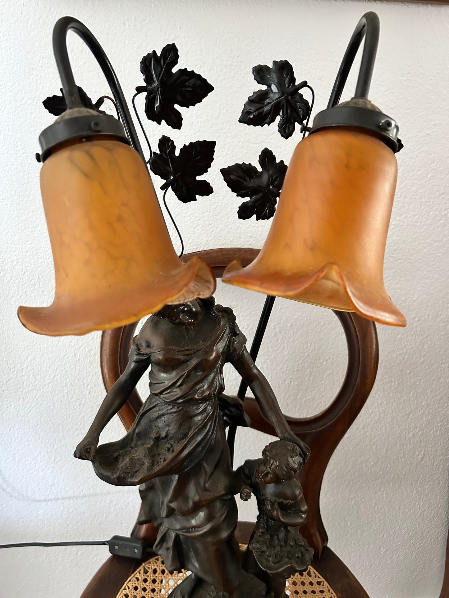 Close-up of amber glass petal shades and decorative metal leaf details